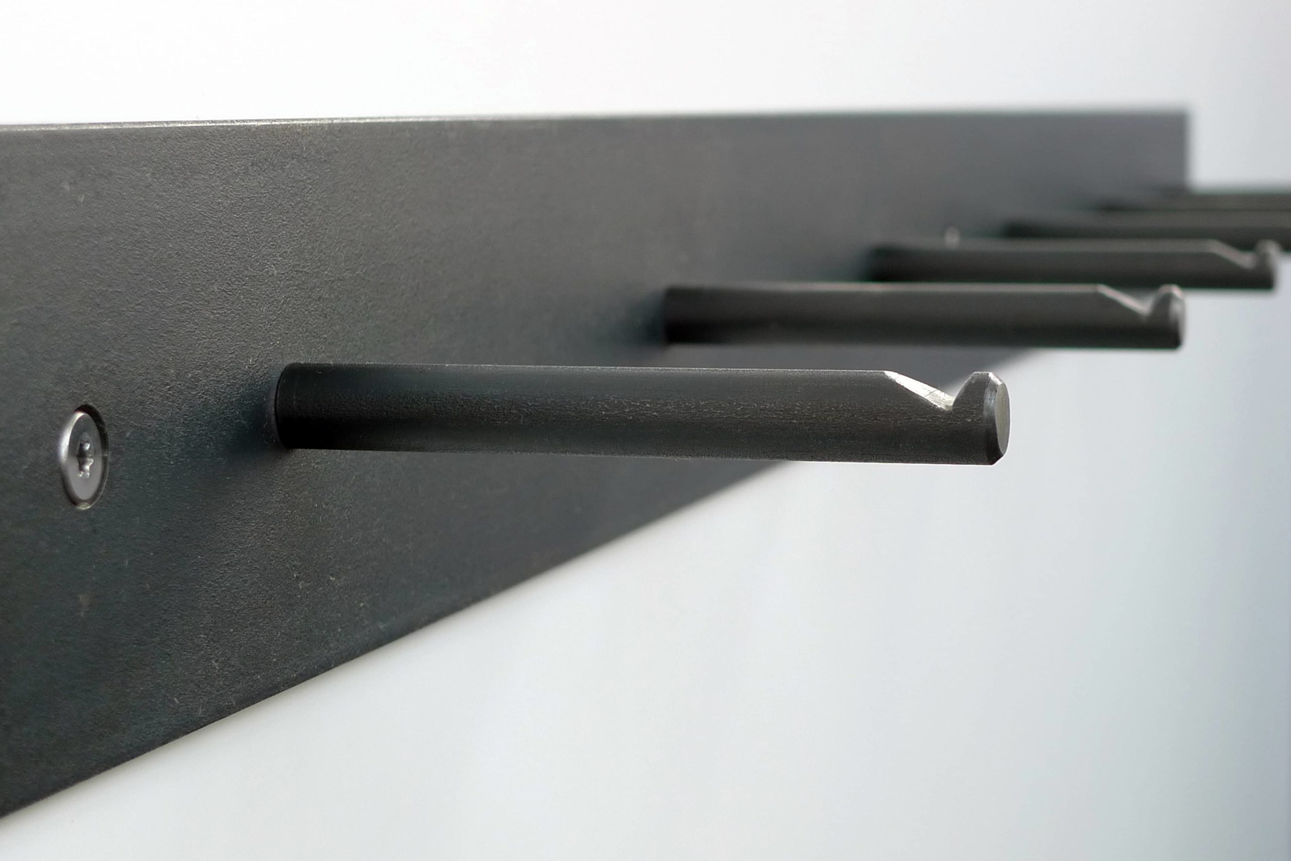 Hellogoodbye coat rack is made of a flat piece of crude steel plus six round hooks with notches to prevent clothes or coat hangers from sliding off.