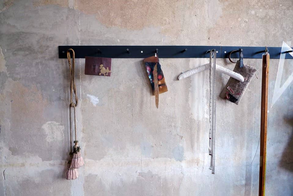 Hellogoodbye coat rack is made of a flat piece of crude steel plus six round hooks with notches to prevent clothes or coat hangers from sliding off.